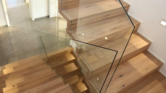 Treppe mit Geländer aus Glaswänden und Holzstufen von BECK Treppen